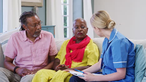 female community nurse visits senior couple at home