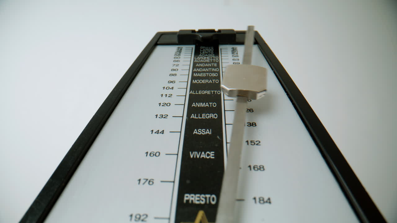 Closeup metronome swinging white background. Macro view pendulum ticking beats