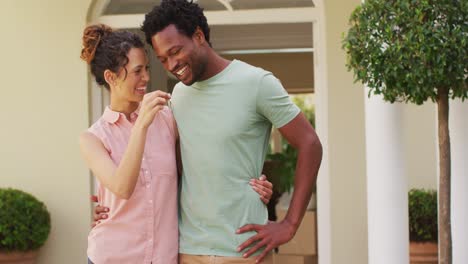 happy biracial couple holding keys to new house