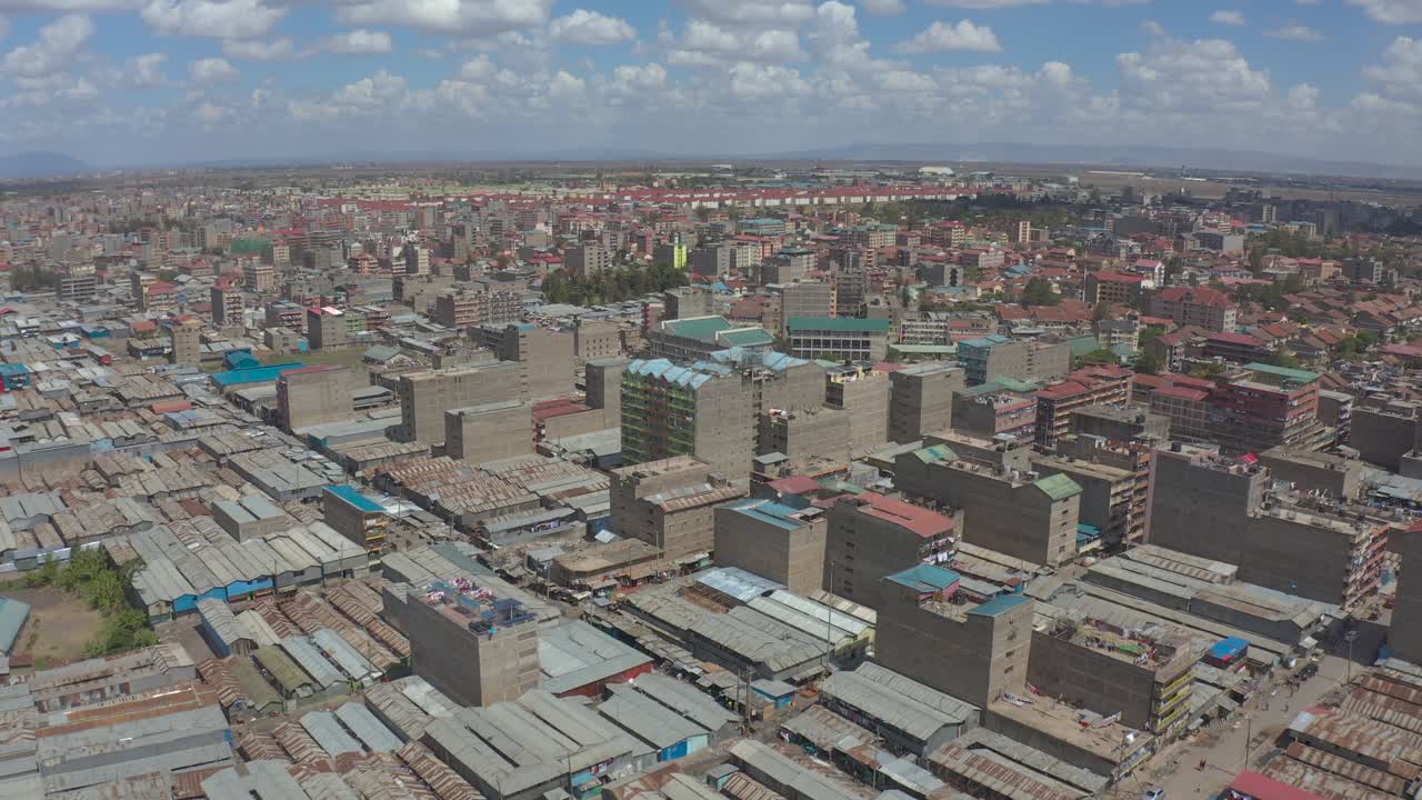 Nairobi'de düşük gelirli bir mahalle olan Kware'nin, paslı teneke çatılar ve yüksek binaları gösteren drone çekimi
