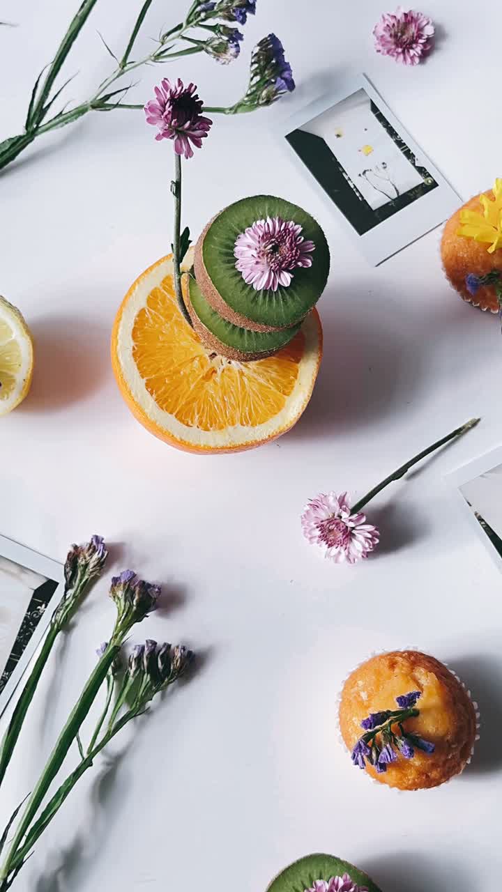 Et smukt arrangement af frugt, blomster og cupcakes