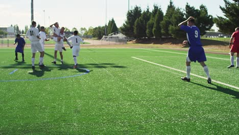 a soccer team celebrates making a goal