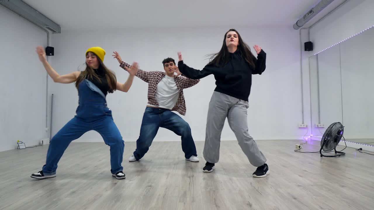 Three people dancing in a studio