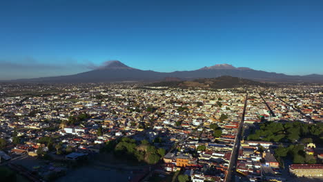 aerial view backwards passing the cholula pyramid, sunny evening in puebla, mexico