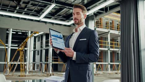 businessman presenting real estate project data on tablet at construction site