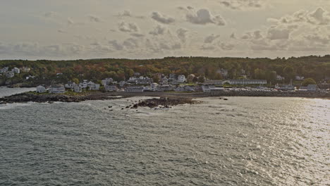 ogunquit maine aerial v3 pan shot of coastal homes and rocky shores at oarweed and perkins cove with shimmering sunlight reflection on water surface - shot with inspire 2, x7 camera - october 2021