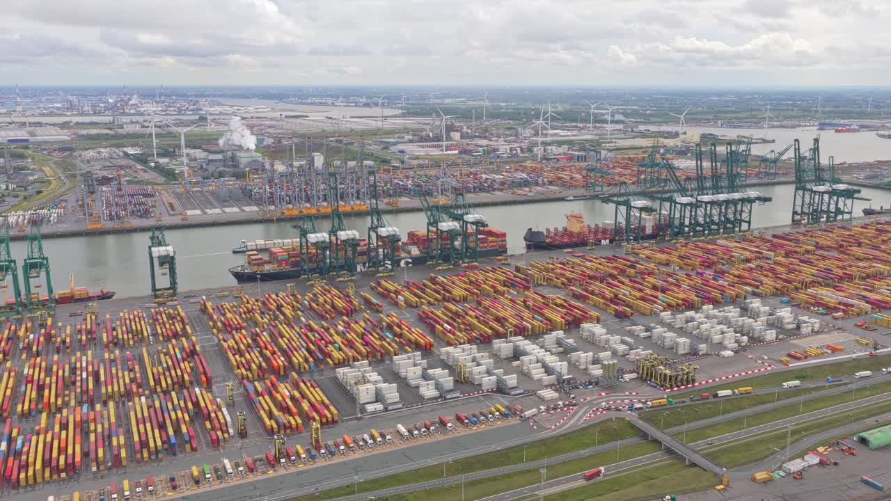 Containerhavn med kraner og industriområder set fra luften.