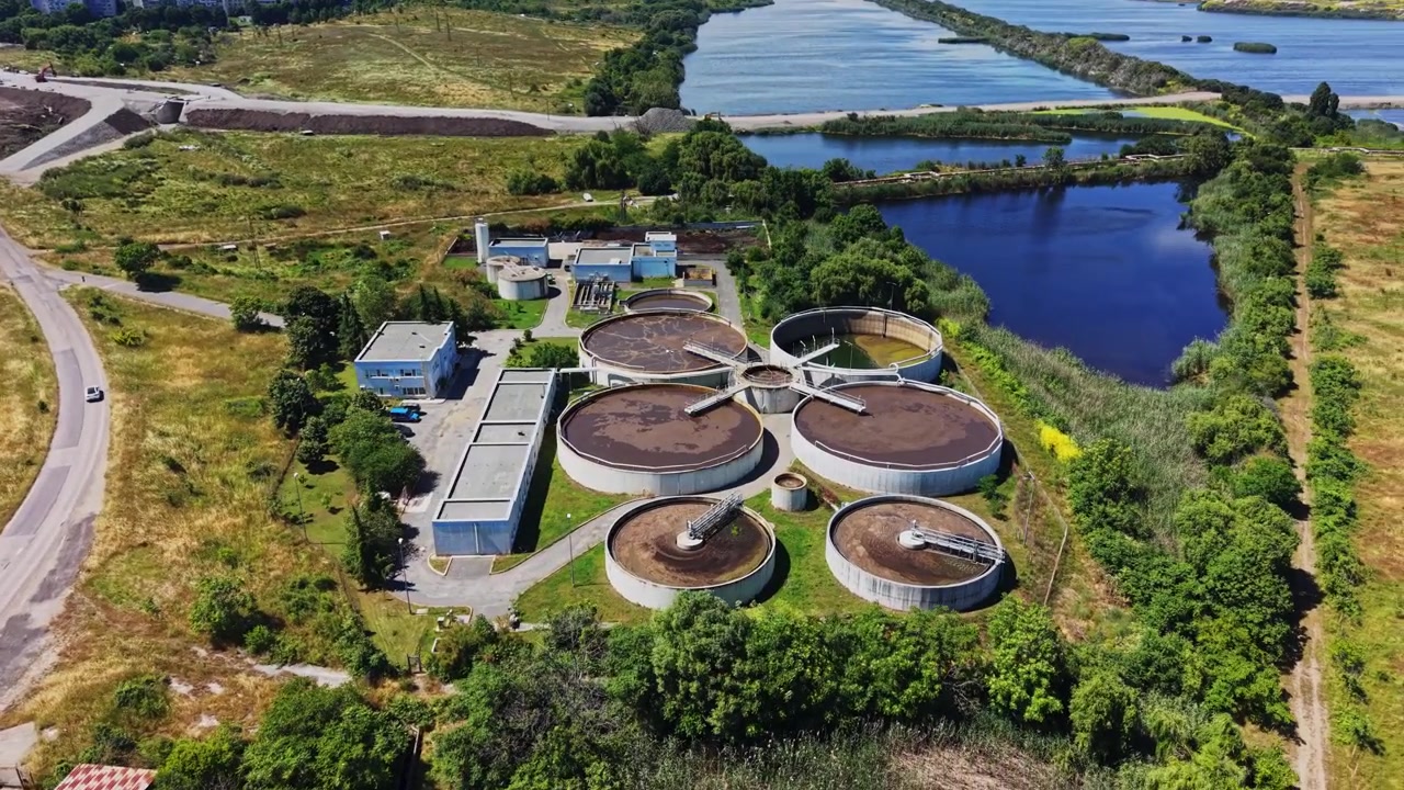 Water treatment facility located near a river with green fields and roads
