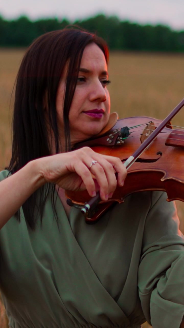 Woman Playing Violin in a Field at Sunset