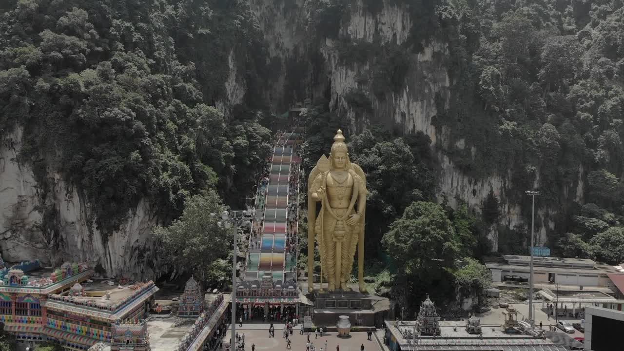 Drone shot of. the huge Buddha by Batu Caves in Malaysia. Shot shows a forward motion of the drown, about 200ft above the crowd.