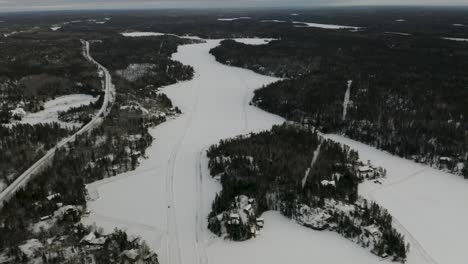 Caminos-De-Hielo-Esparcidos-Por-Todo-El-Lago-Congelado-Escondido-Entre-El-Bosque-Boreal-En-El-Norte-De-Canadá