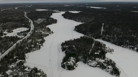 caminos de hielo esparcidos por todo el lago congelado escondido entre el bosque boreal en el norte de canadá
