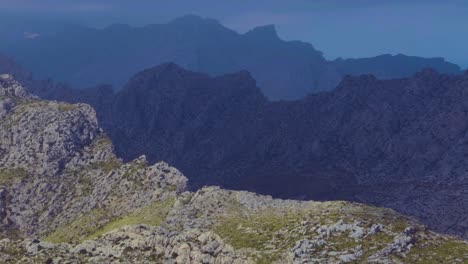 A-view-of-peak-mountains-over-top-of-the-mountains-making-a-cinematic-view,-the-background-mountains-are-in-the-dark-view-by-the-clouds