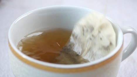 Green-tea-and-tea-bag-on-table,-close-up