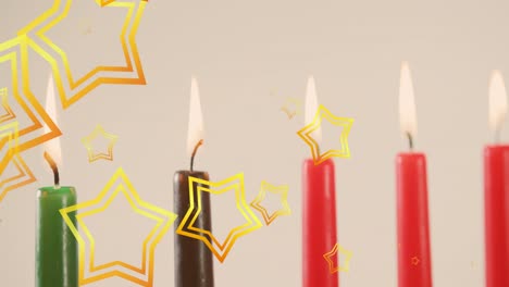 animation of golden stars falling over kwanzaa candles on grey background