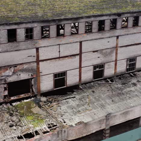 ruined architecture after military actions. abandoned building with broken windows and many hole in walls. damaged building outdoors. aerial view.