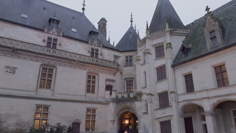 child runs by entrance of château de chaumont in france on cloudy day, tilt down
