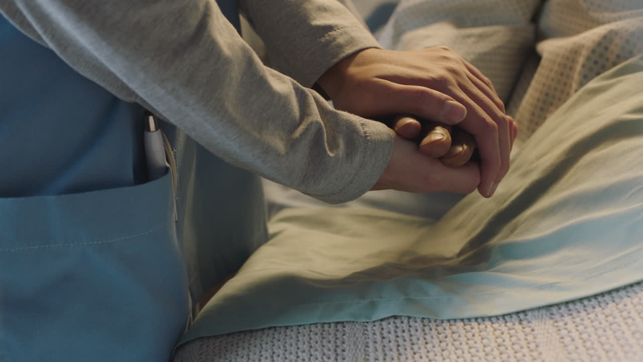 infermiera che tiene la mano di un vecchio nel letto dell'ospedale mostrando affetto per un paziente anziano che si riprende dalla malattia