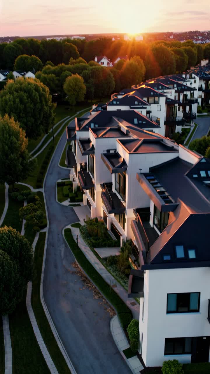 Modern townhouses at sunset captured from a high-angle, showcasing sleek architecture and warm