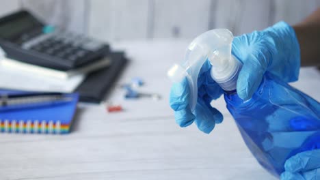 limpieza de un escritorio en el lugar de trabajo con desinfectante