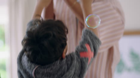 niño lindo jugando con burbujas de jabón en casa madre y padre divirtiéndose con el niño en casa disfrutando del tiempo en familia el fin de semana