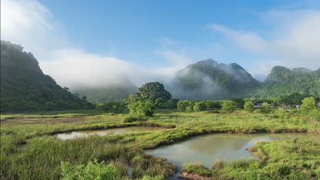 timelapse of low hill with misty mountain range background