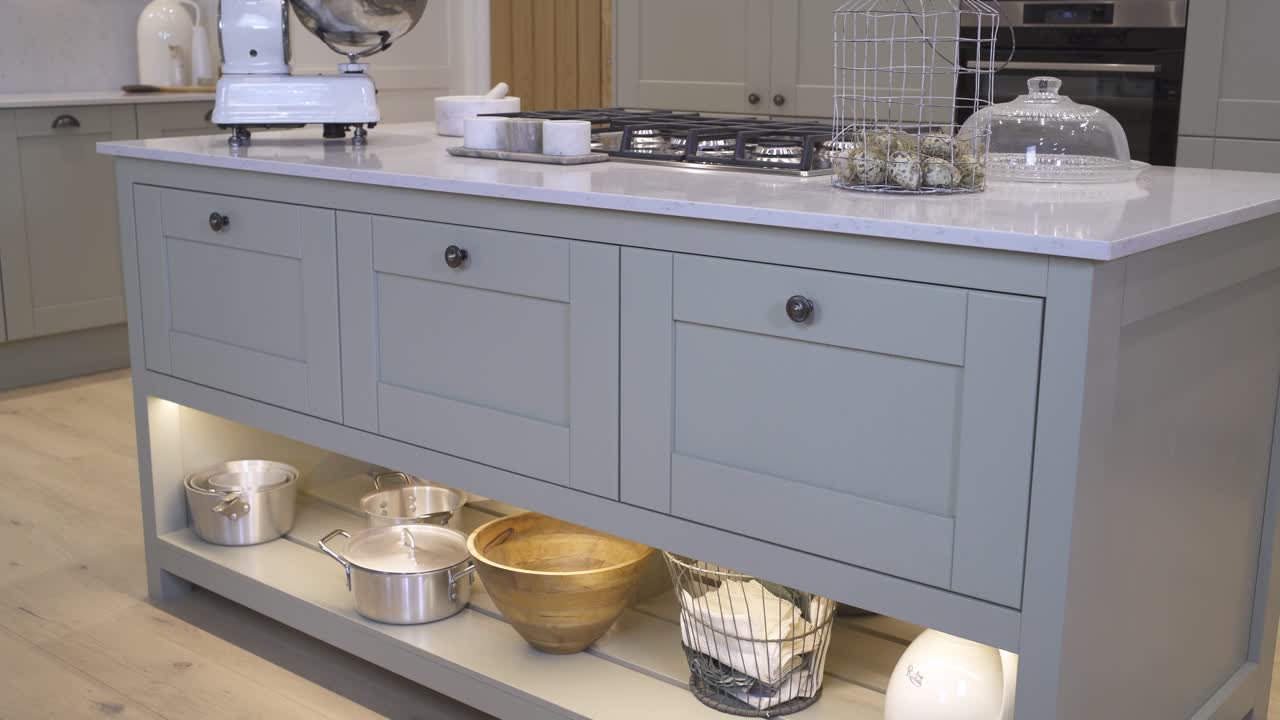 White marble kitchen island with grey cabinets in a luxury kitchen.