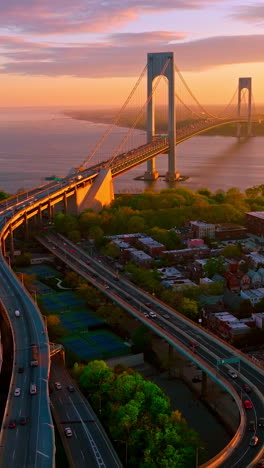 complicated system of roads leading to throgs neck bridge. impressive bridge structure in the rays of setting sun. vertical video