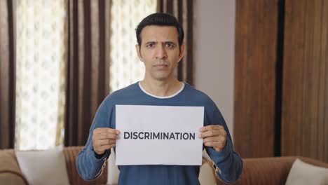 hombre indio enojado sosteniendo una pancarta de discriminación