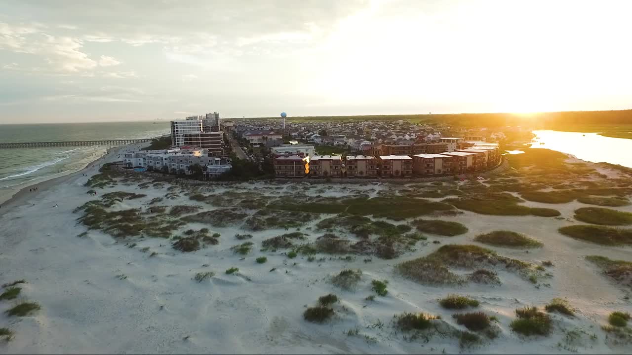 drone volando lejos de la entrada hacia el continente al atardecer