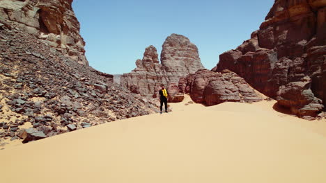 Man-Standing-On-The-Sand-Dune-In-Djanet-Desert,-Algeria---aerial-drone-shot