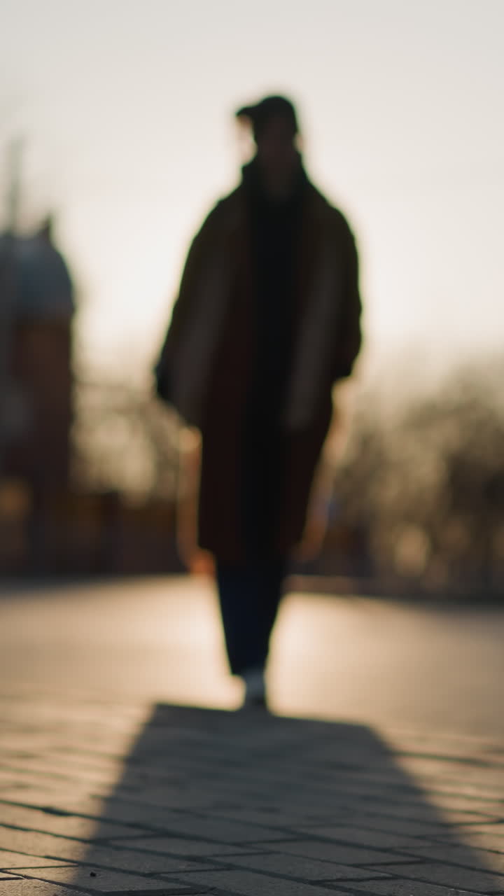 해가 지는 공원에서 슬 속에서 천천히 걸어가는 사람의 실루이 보이고, 배경과 전면이 모두 흐릿하여 부드럽고 우울한 분위기를 만니다.