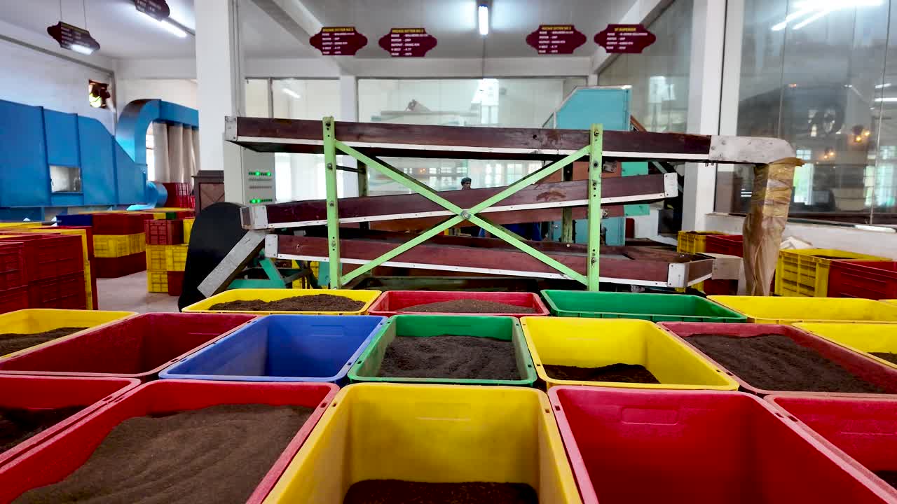 Rows of colorful crates filled with different types of tea in a Sri Lankan tea factory.