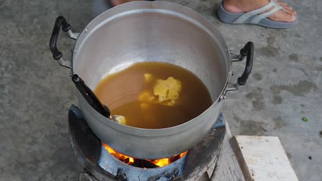 preparing tamarind sauce in metal pot over fire stove