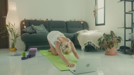 woman doing yoga at home with online class