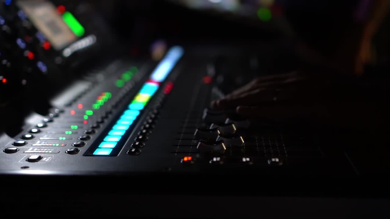 Mixing consolle with blinking volume level, lateral view with blurred background