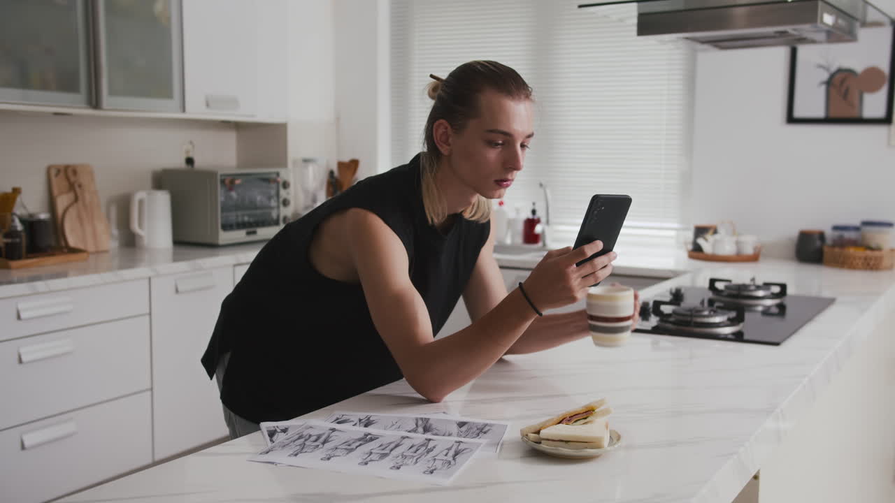 Male Designer Checking Smartphone during Home Breakfast