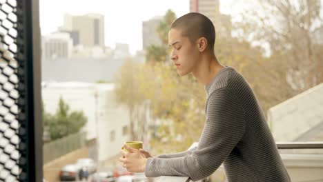 man having coffee while standing in balcony 4k