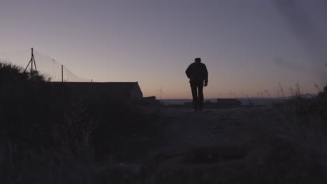 granjero caminando por sus campos por la mañana temprano