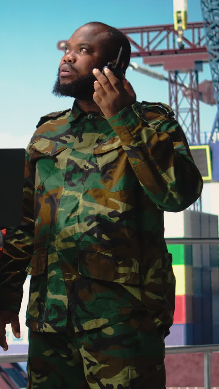 Vertical video Soldier working on offshore platform communicating via military radio