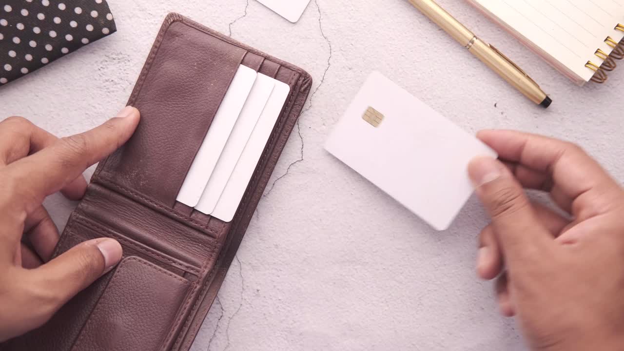 persona poniendo una tarjeta de crédito en una billetera