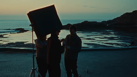 film crew working on location at sunset