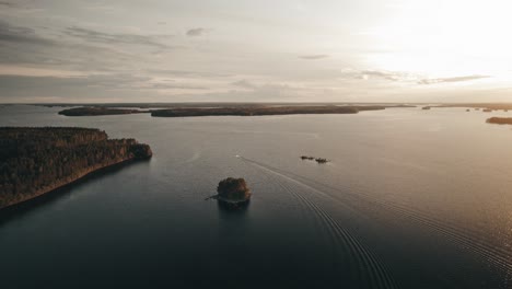 Aerial,-Drone,-Sunset-over-lake-with-boat,-Finland