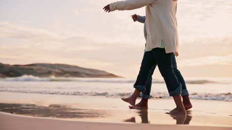 couple, holding hands and walking on beach