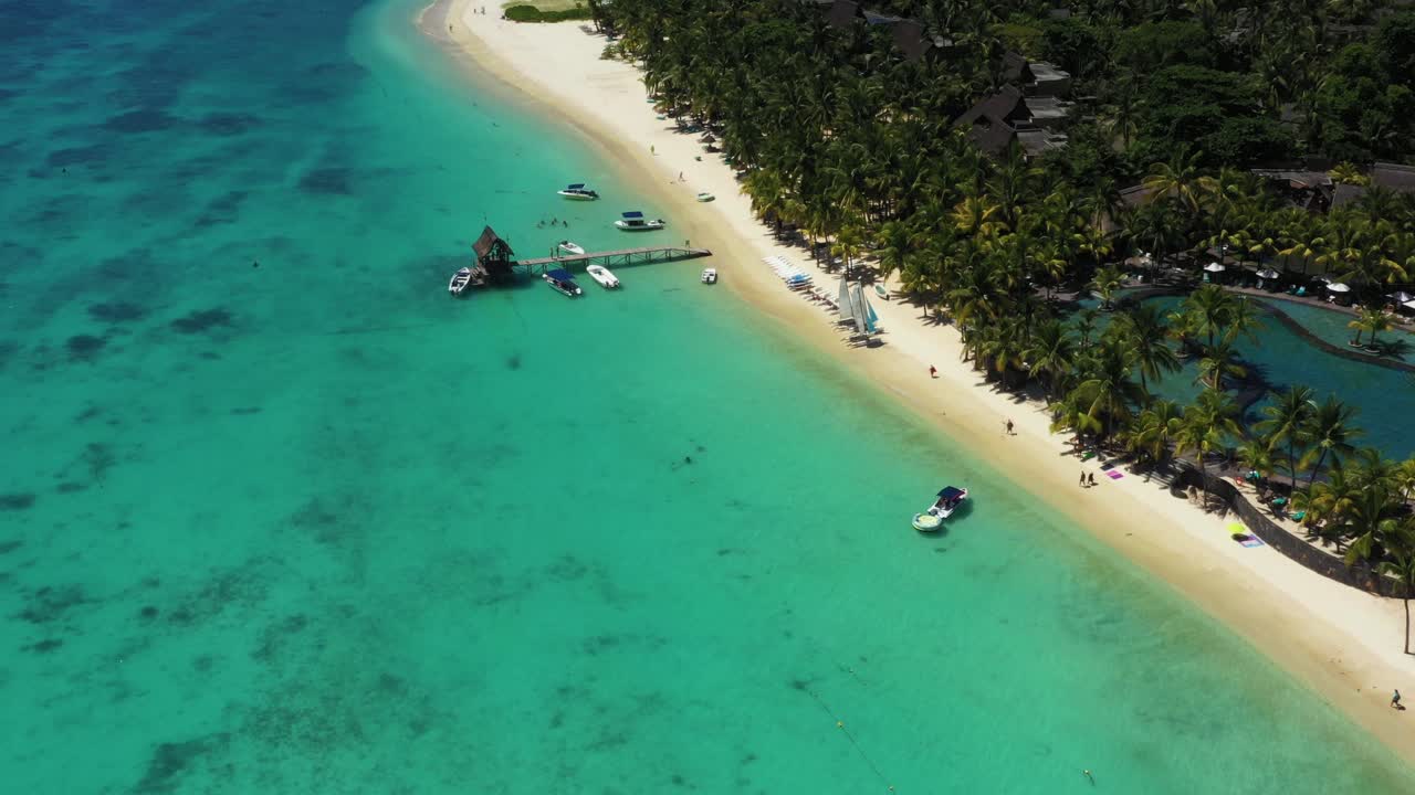 Spiaggia, barriera corallina e palme lungo il litorale di Mauritius, Africa. Molo vicino alla spiaggia dell'isola.