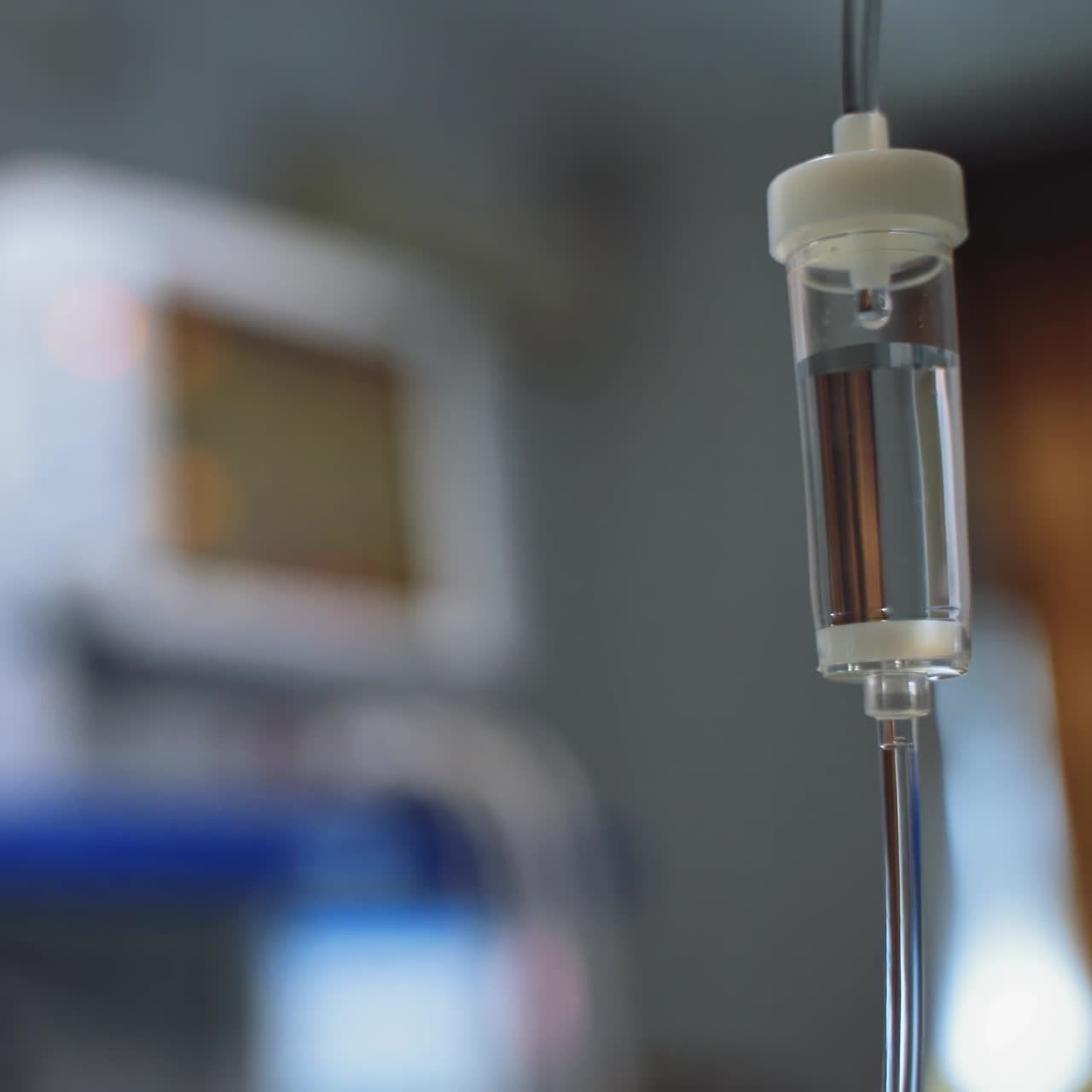 Medical instruments in the operating room. Dropper with medicine on the blurred background with a computer in the intensive care unit. Close-up.