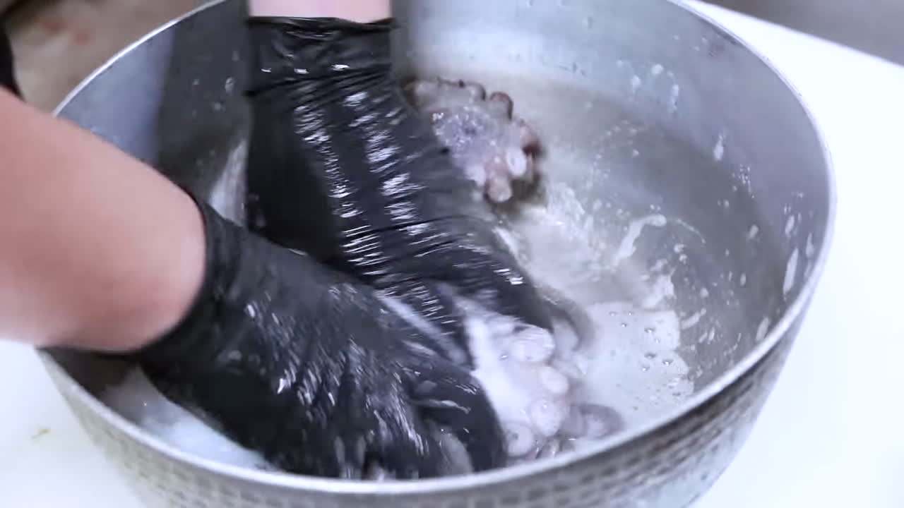 un chef limpia pulpo. mariscos crudos