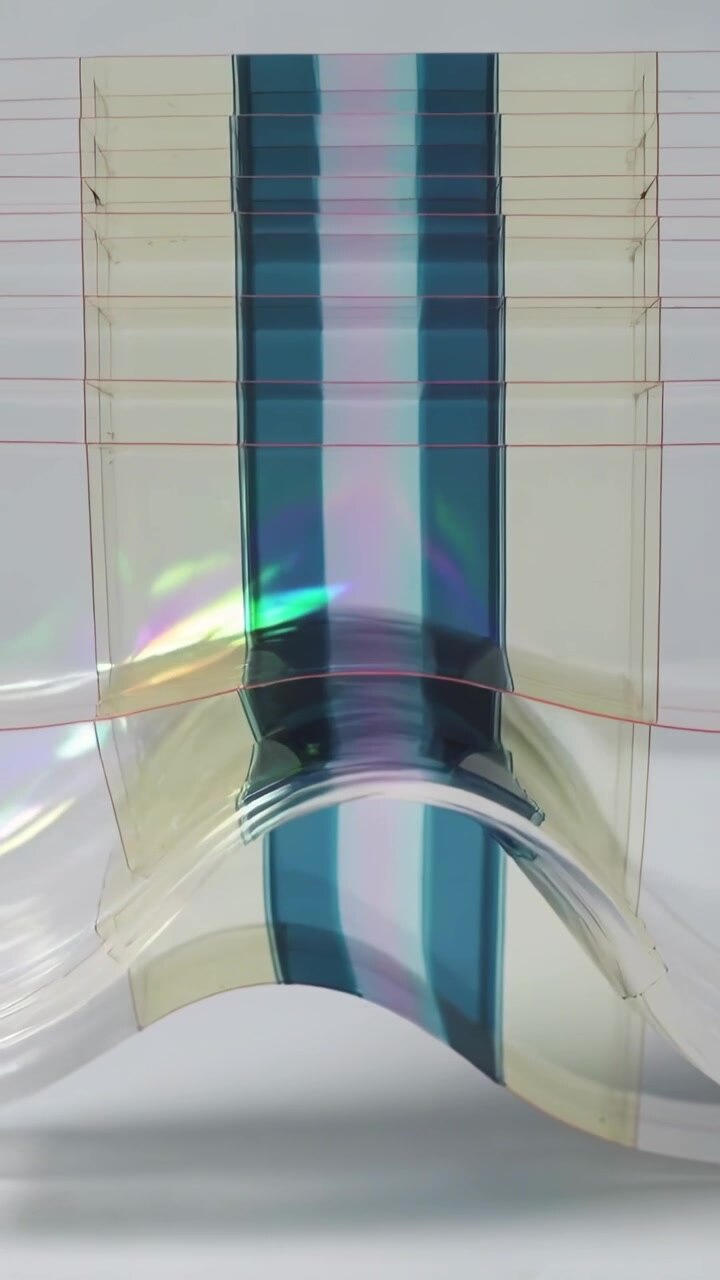Vertical video: Pushing lower edge, striped film bowing on tabletop showing red guide lines warp