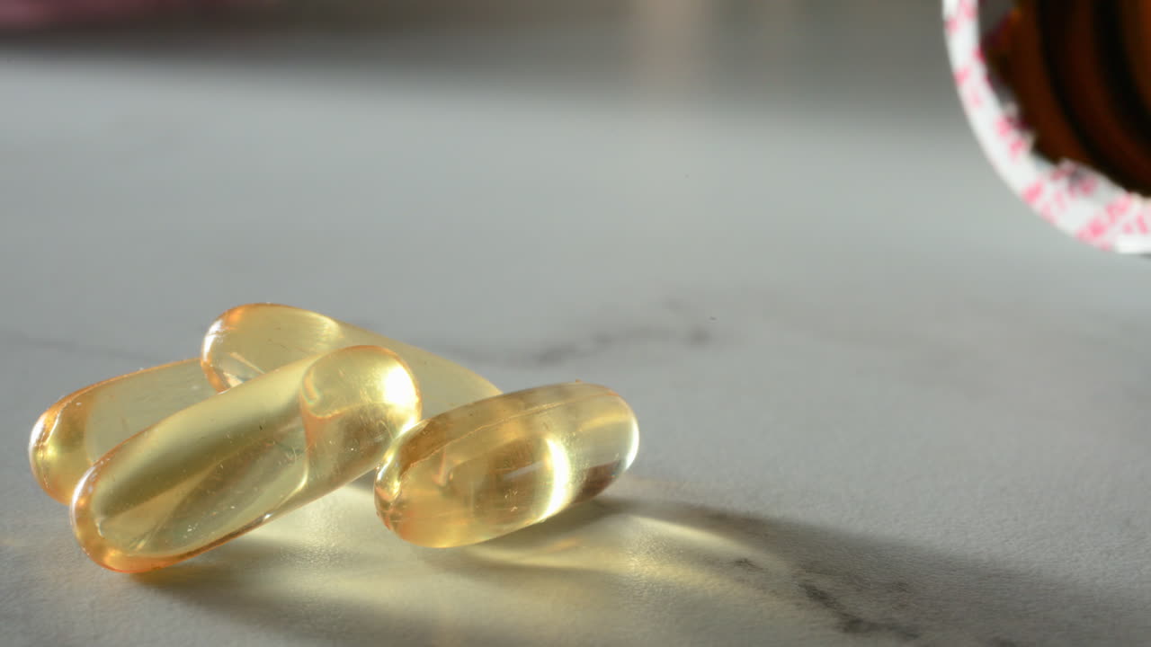 Close up of fish oil supplements scattered on a white table