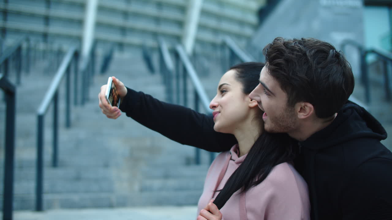 una pareja divertida posando para una selfie.